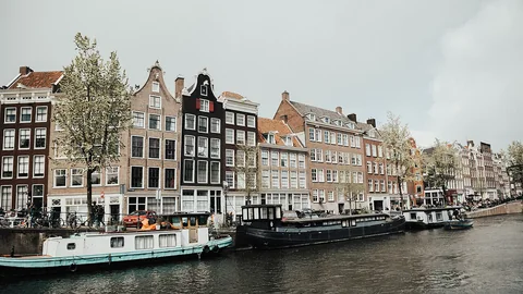 Grachtenpanden en boten langs het water in Amsterdam
